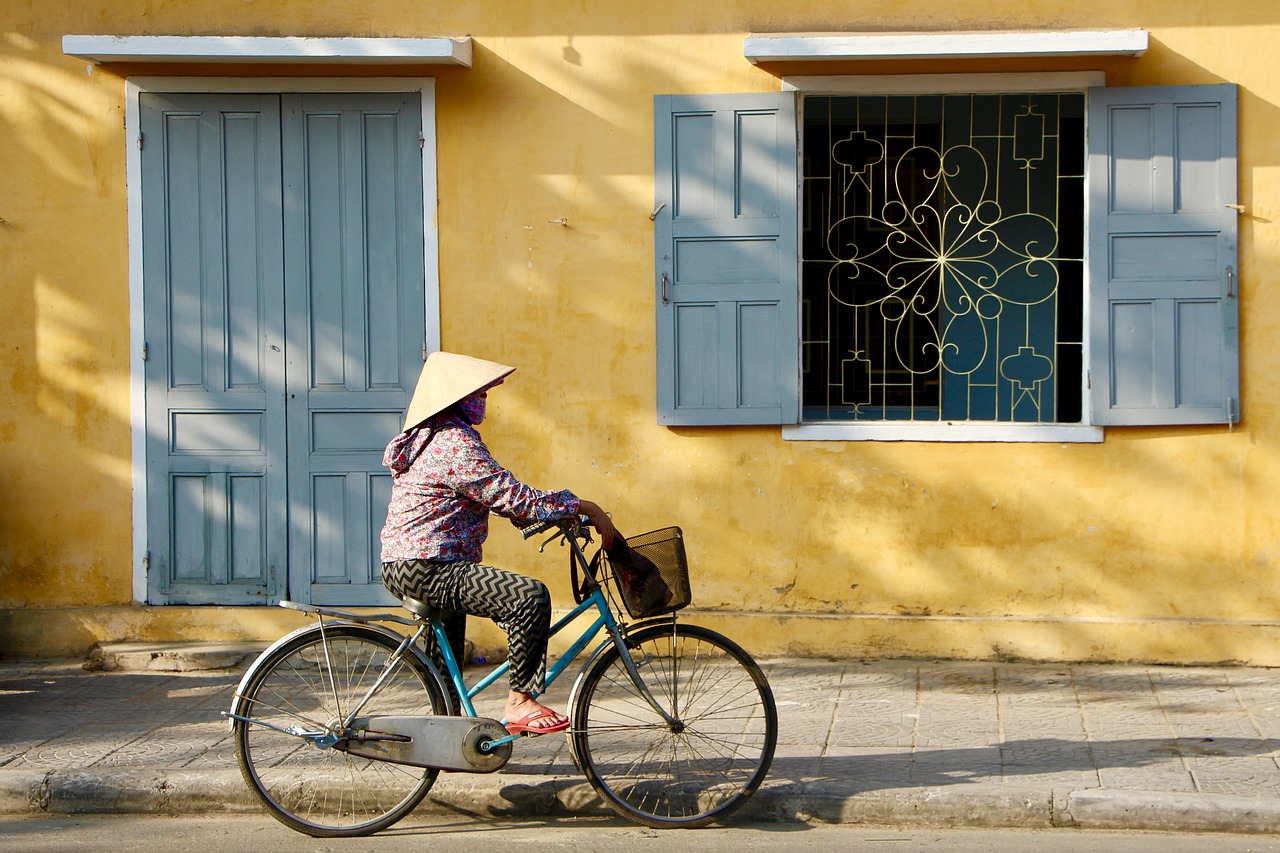 Fahrradfahrerin vor eine Hauswand in Ho An